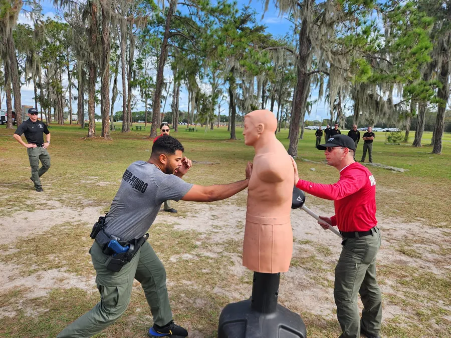 Instructor assisting cadet with Soloplex hit on training dummy