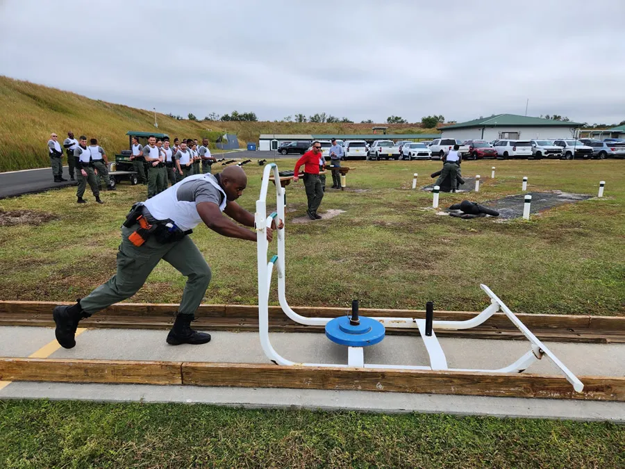 A participant performing a sled push/pull exercise with determination and strength.