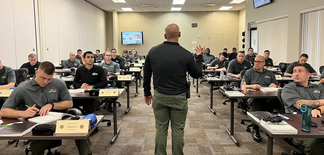 An instructor teaches a class while cadets listen intently.