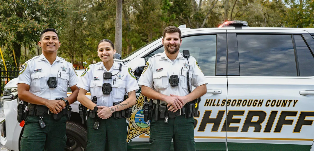 Three law enforcement deputies standing together in uniform