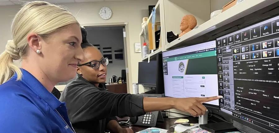 Two employees focused on their work, looking at computer monitors